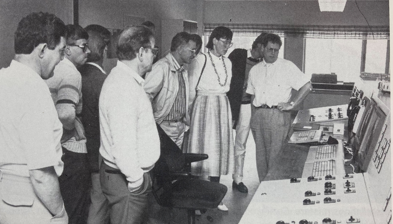 människor samlas i kontrollrummet på det nybyggda värmeverket och står och tittar på skärmar. Bilden är svartvit och tagen 1985.